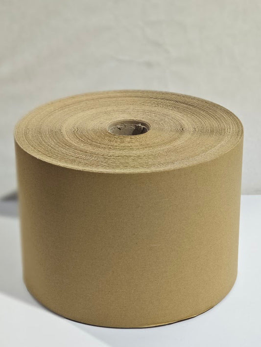 A large roll of brown kraft paper tape or wrapping material on a spool, photographed against a neutral light gray background.